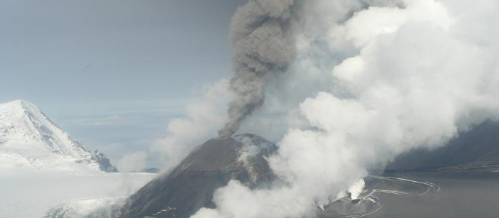 Aerial view of Veniaminof shows gray-brown ash column rising from the active vent, Alaska