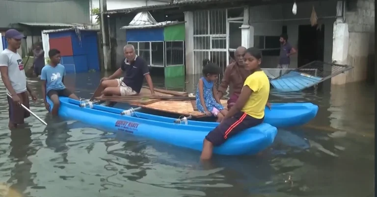 People wading through flood waters on makeshift rafts in Sri Lanka.