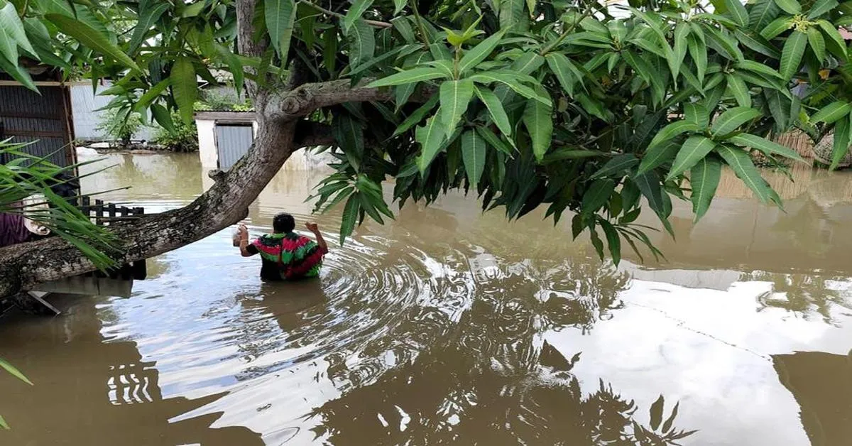 A villager wading through flood water after heavy rain in Sidenreng Rappang Regency, South Sulawesi, Indonesia, July 4, 2024.