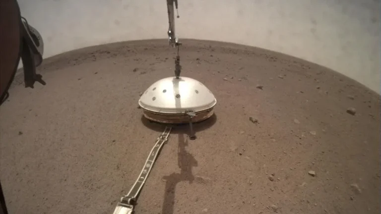 A camera on the robotic arm of NASA’s InSight captured the lander