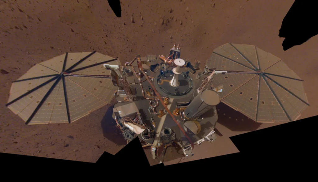 NASA’s InSight took this selfie in 2019 using a camera on its robotic arm. The lander also used its arm to deploy the mission’s seismometer, whose data was used in a 2025 study showing impacts left chunks of debris deep in the planet’s interior. NASA/JPL-Caltech
