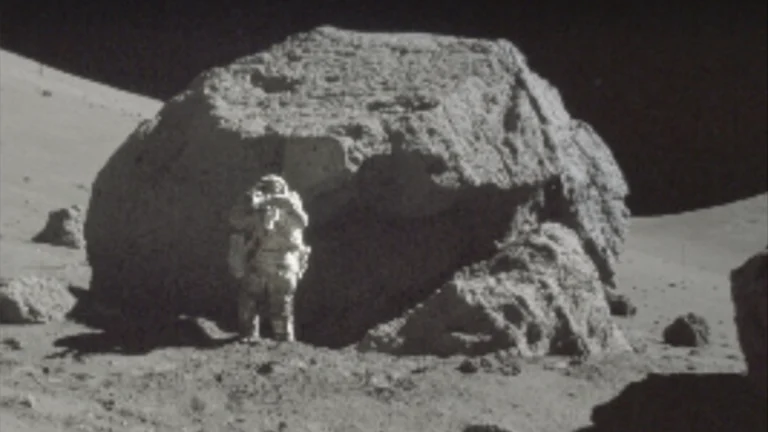 Astronaut with a lunar boulder.