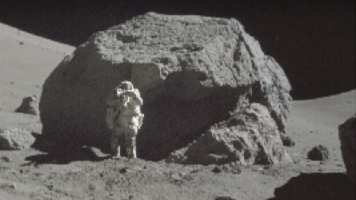 Astronaut with a lunar boulder.
