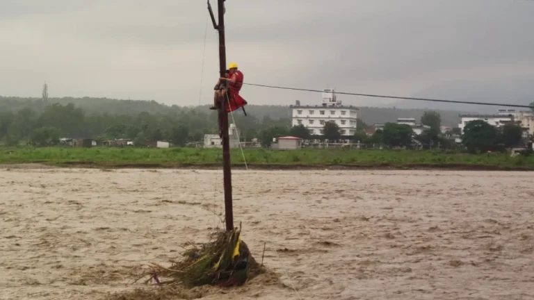 NDRF operative rescuing a teen who climbed up and electric to save himself from the flooding in Uttarakhand on September 16, 2025. Credit: NDRF