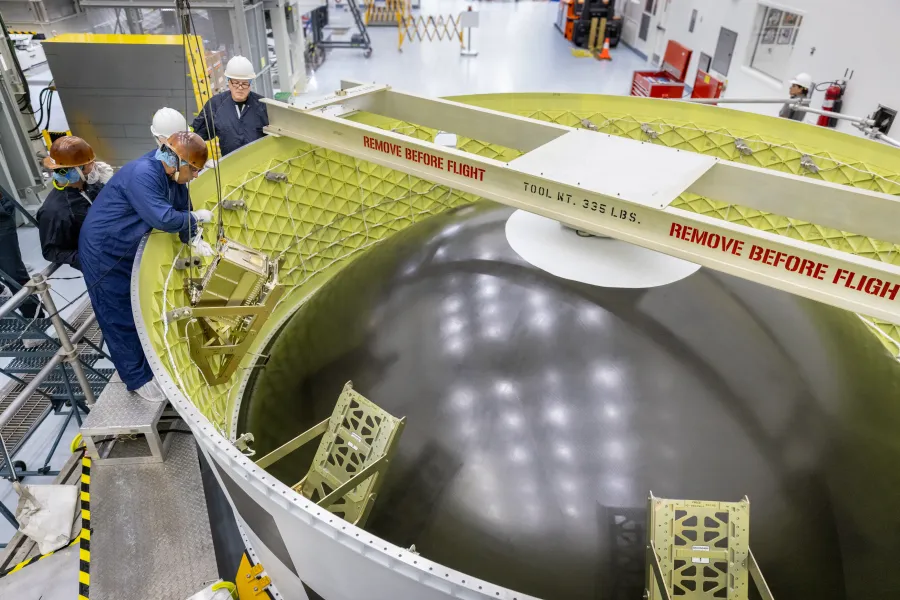 Technicians install the Korea AeroSpace Administration (KASA) K-Rad Cube within the Orion stage adapter inside the Multi-Payload Processing Facility at NASA’s Kennedy Space Center in Florida on Tuesday, Sept. 2, 2025. The K-Rad Cube, about the size of a shoebox, is one of the CubeSats slated to fly on NASA’s Artemis II test flight in 2026.Credit: NASA