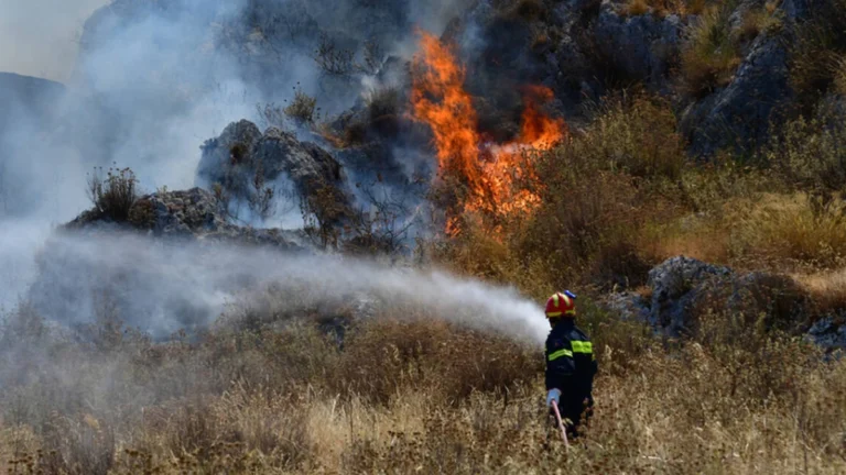 Firefighter suppressing a wildfire in central Greece on July 28, 2026