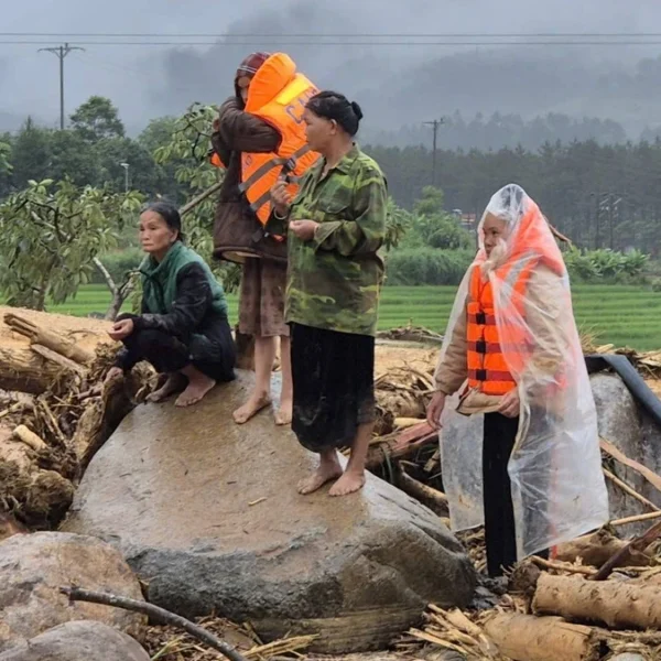 People rescued from floods and landslide in Muo Than Commune on July 18, 2026 standing on the rubble left in the aftermath in Lai Chau, Vietnam
