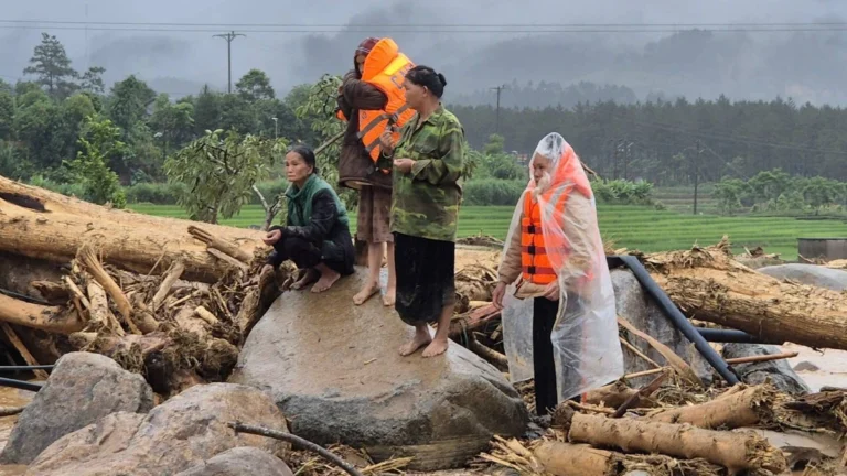 People rescued from floods and landslide in Muo Than Commune on July 18, 2026 standing on the rubble left in the aftermath in Lai Chau, Vietnam