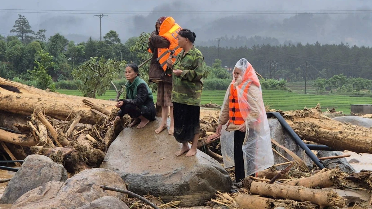 People rescued from floods and landslide in Muo Than Commune on July 18, 2026 standing on the rubble left in the aftermath in Lai Chau, Vietnam