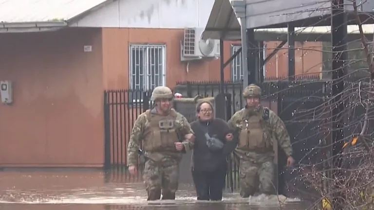 Woman being rescued from her flooded home in Angol, Chile on August 3, 2026