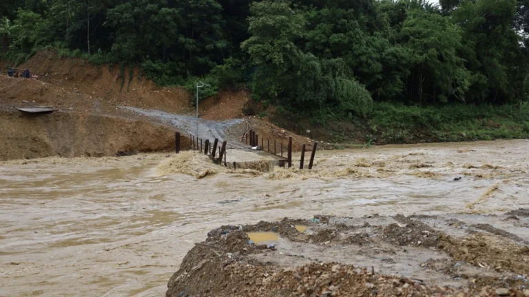 Floodwaters wash away a temporary bridge in Nghe An Province following heavy rain in August