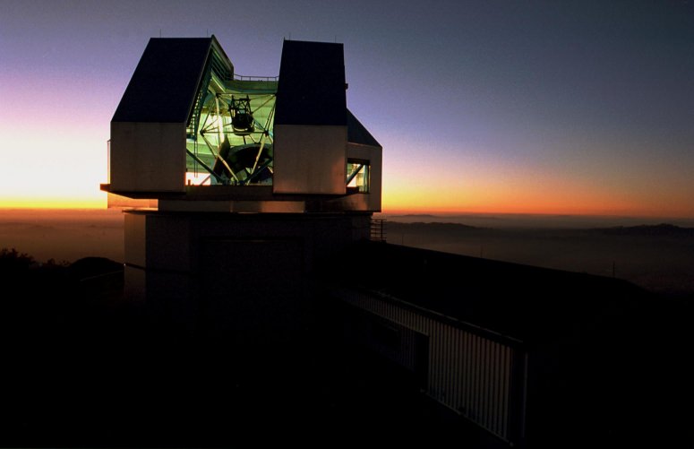 The WIYN telescope building against a sunset sk
