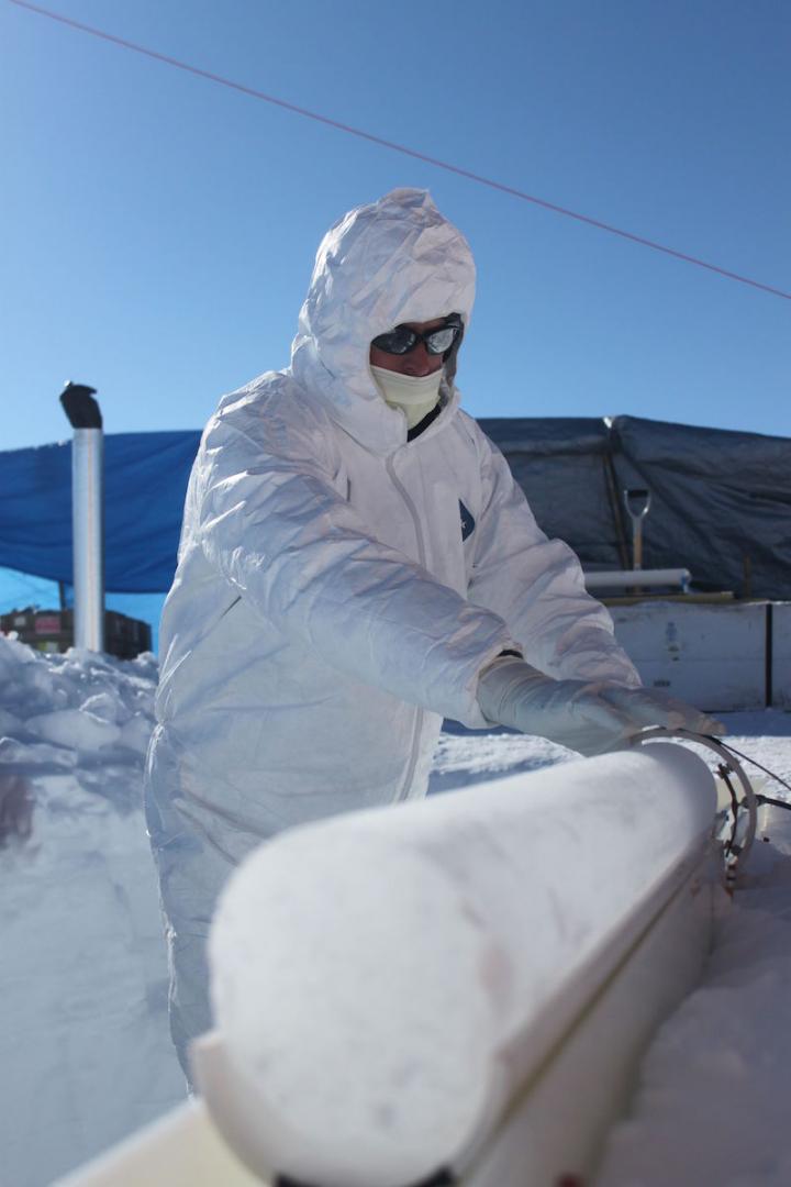 A researcher inspects an ice core collected from Greenland